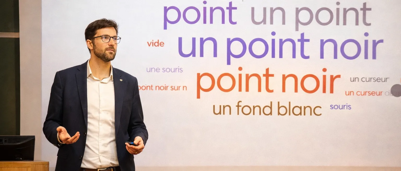 Jimmy Materne en intervention, devant l'écran où s'affichent en direct les réponses de la salle