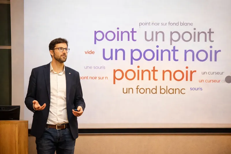 Jimmy Materne en intervention, devant l'écran où s'affichent en direct les réponses de la salle